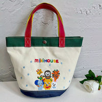 Tote bag with colorful handles and cartoon characters on a white surface.