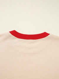 Close-up of a beige sweater with a red neckline on a beige background