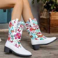 White boots with colorful floral patterns on a wooden floor.