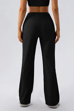 Person wearing black high-waisted pants on a white background