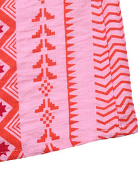 Close-up of pink fabric with red geometric patterns on a white background