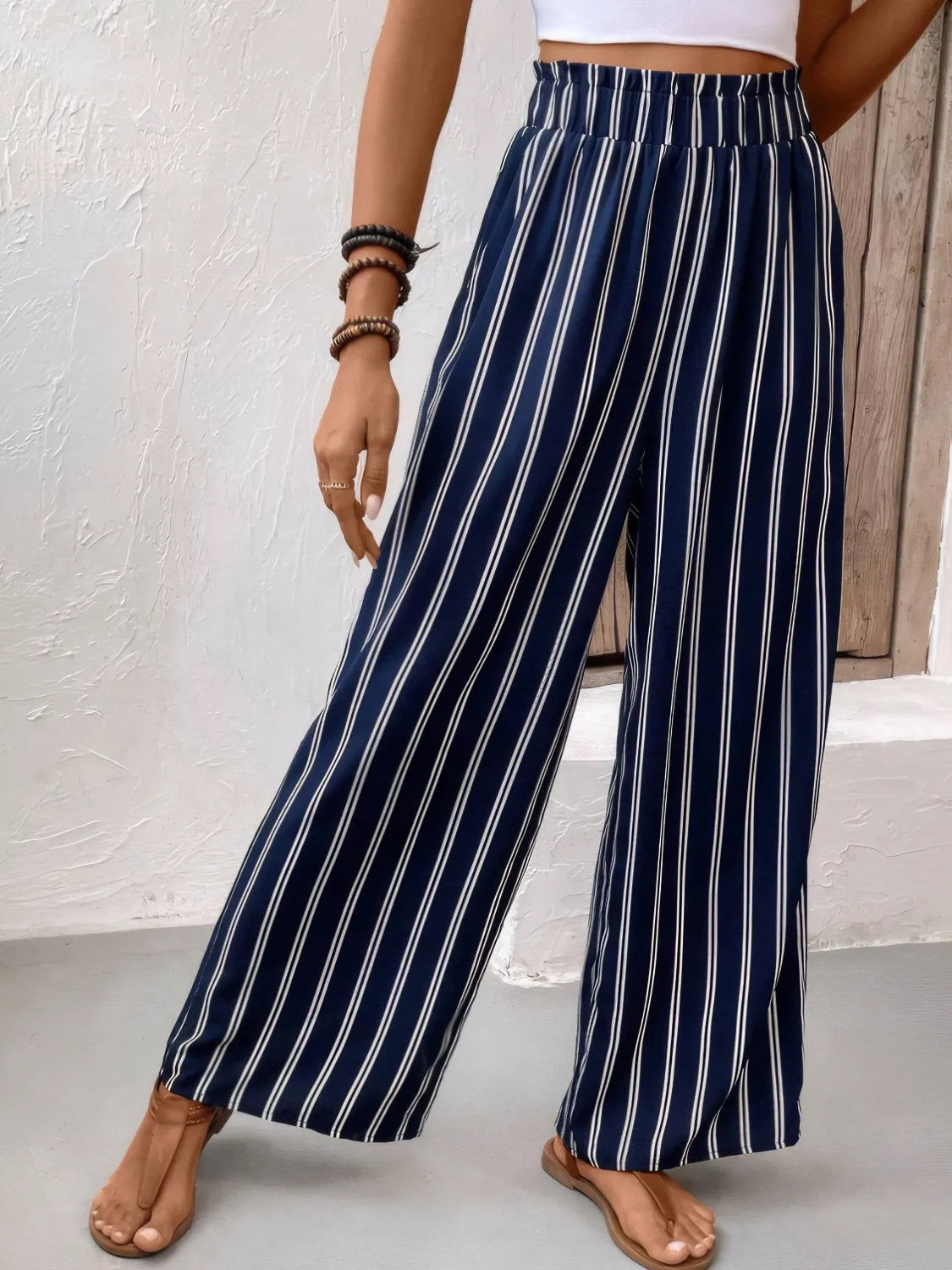 Navy and white striped wide-leg pants worn by a person on a neutral background