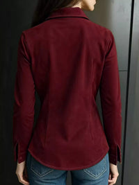 Person wearing a burgundy jacket against a dark background
