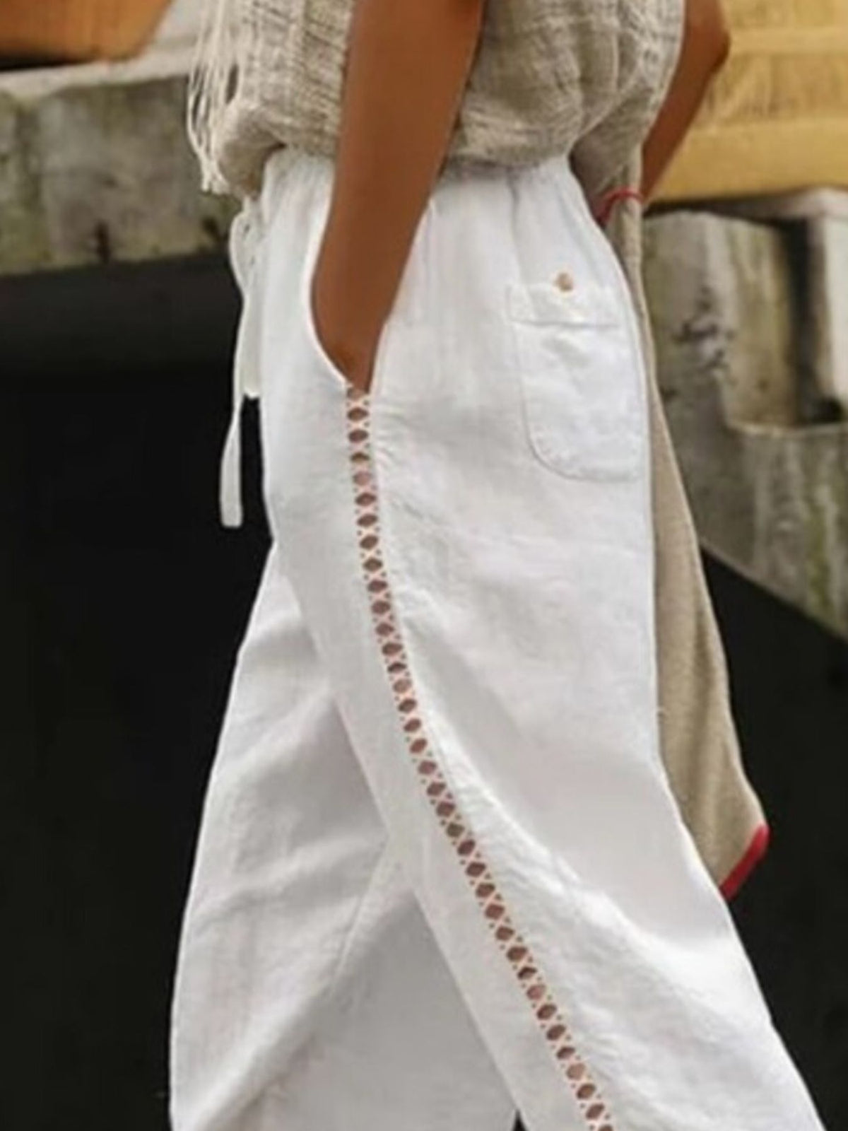 White pants with decorative stitching detail on a blurred background