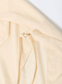 Close-up of a beige fabric with a subtle texture on a light gray background