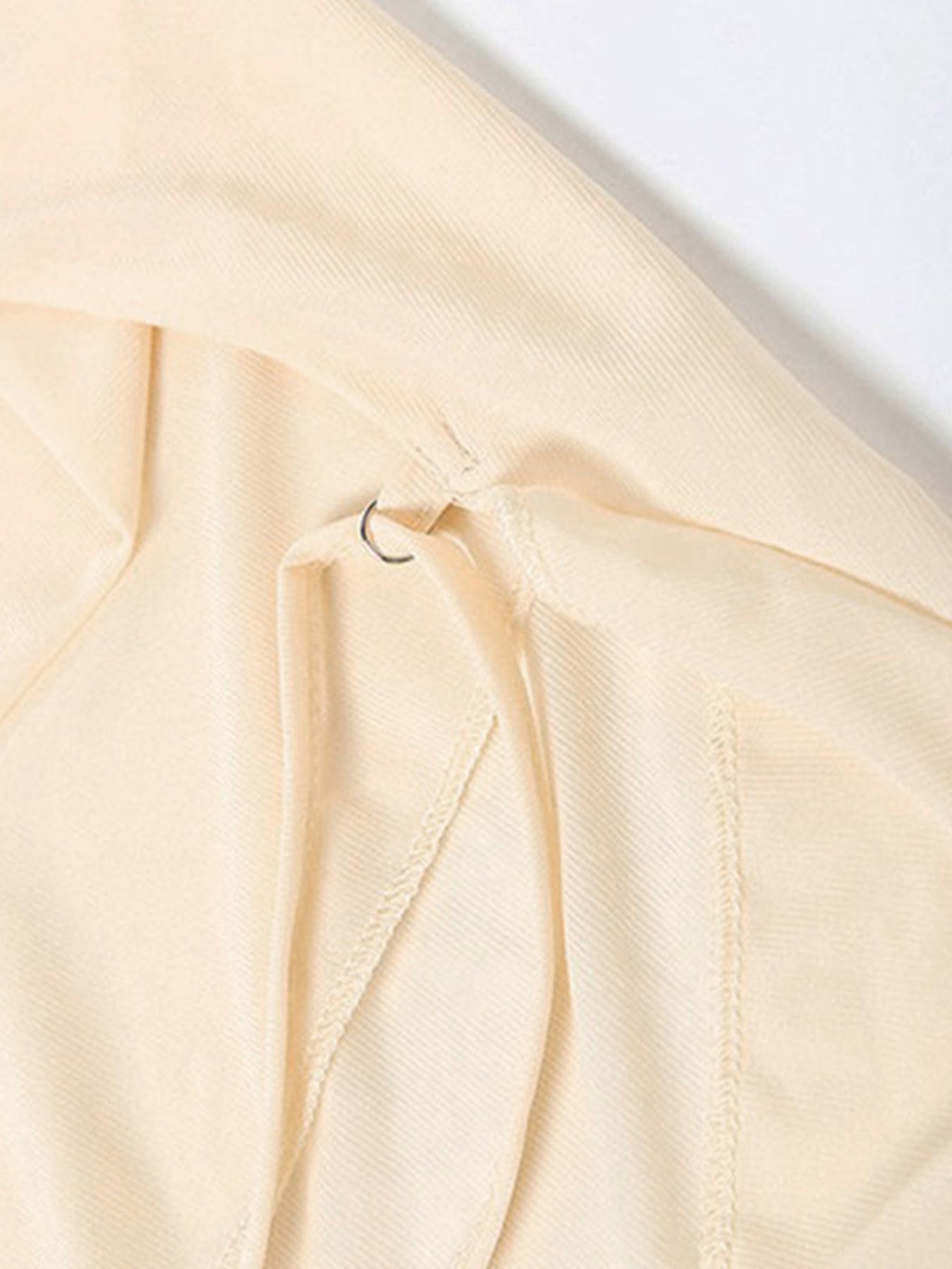 Close-up of a beige fabric with a subtle texture on a light gray background