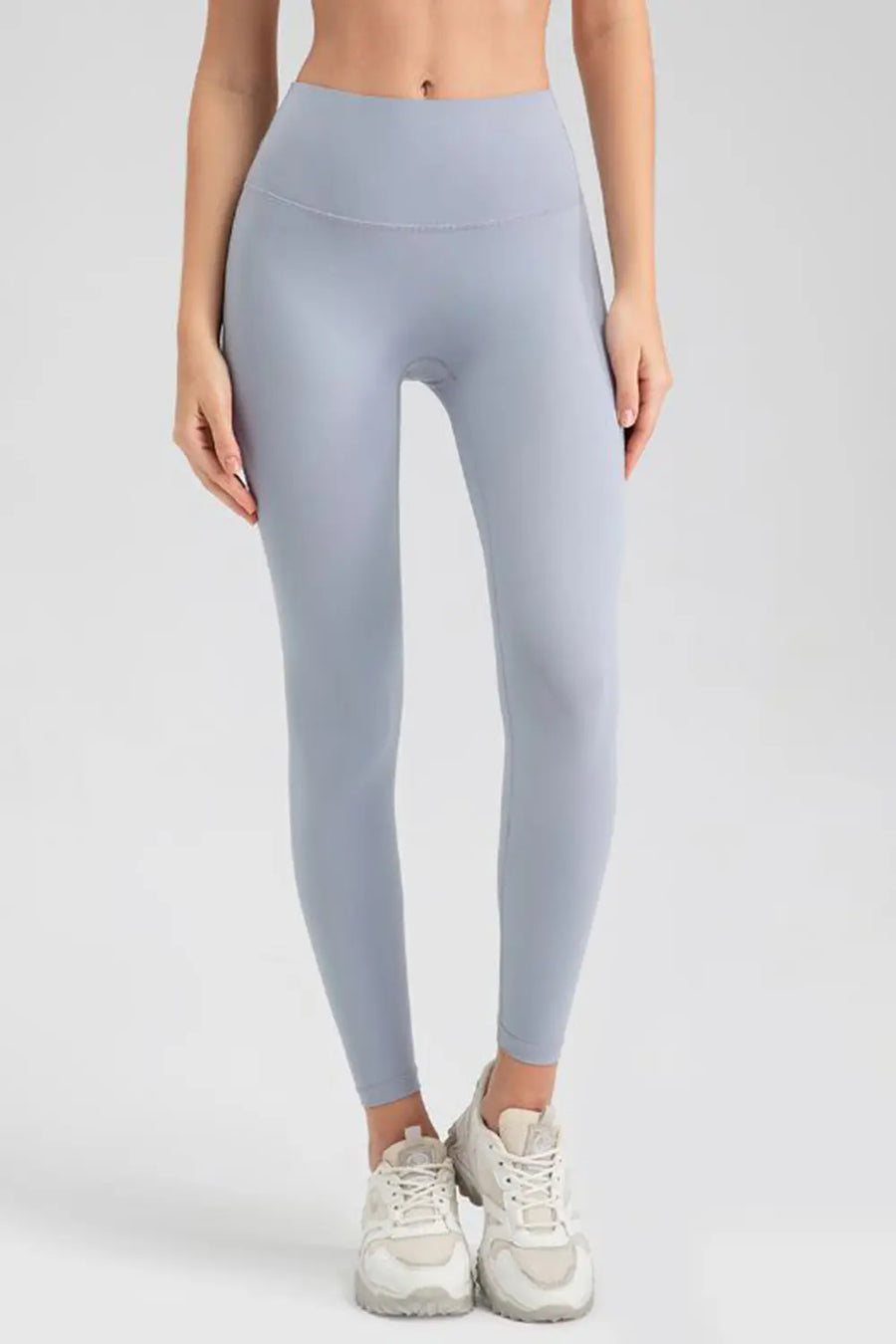 Person wearing light gray leggings on a white background