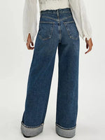 Blue jeans worn by a person on a white background