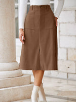 Person wearing a brown skirt standing on stone steps with a neutral background