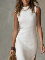 Woman wearing a white sleeveless dress with gold jewelry against a gray background