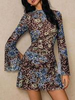 Woman wearing a floral and leopard print dress against a beige background
