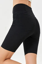 Black shorts worn by a person on a white background