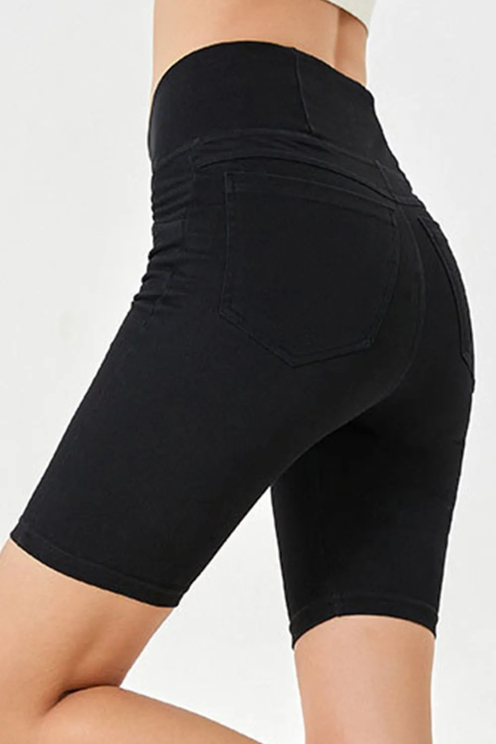 Black shorts worn by a person on a white background