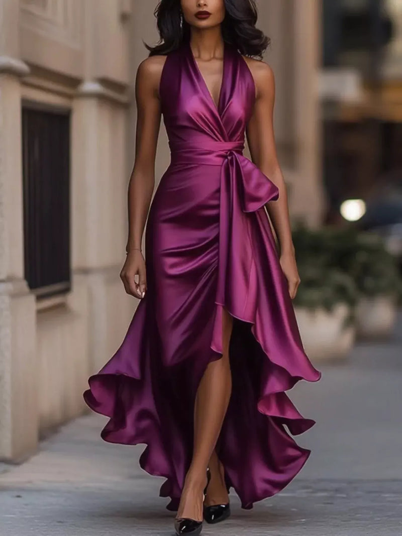 Woman wearing a purple satin dress standing outdoors.