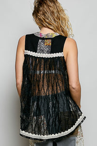 Black lace top with colorful patchwork design on a plain background