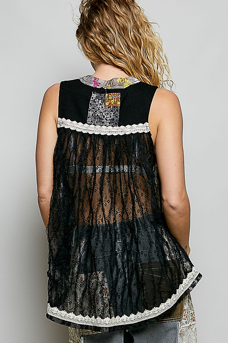 Black lace top with colorful patchwork design on a plain background