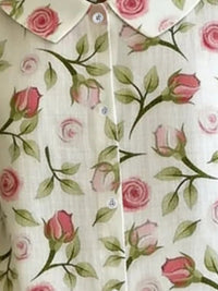 Floral patterned shirt with pink roses and green leaves on a white background