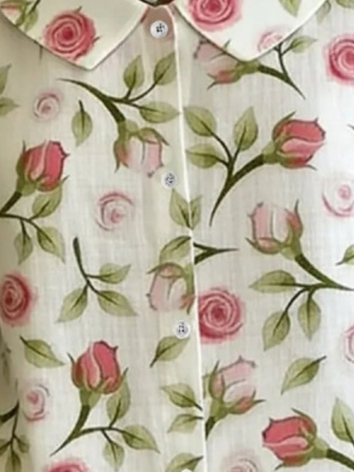 Floral patterned shirt with pink roses and green leaves on a white background