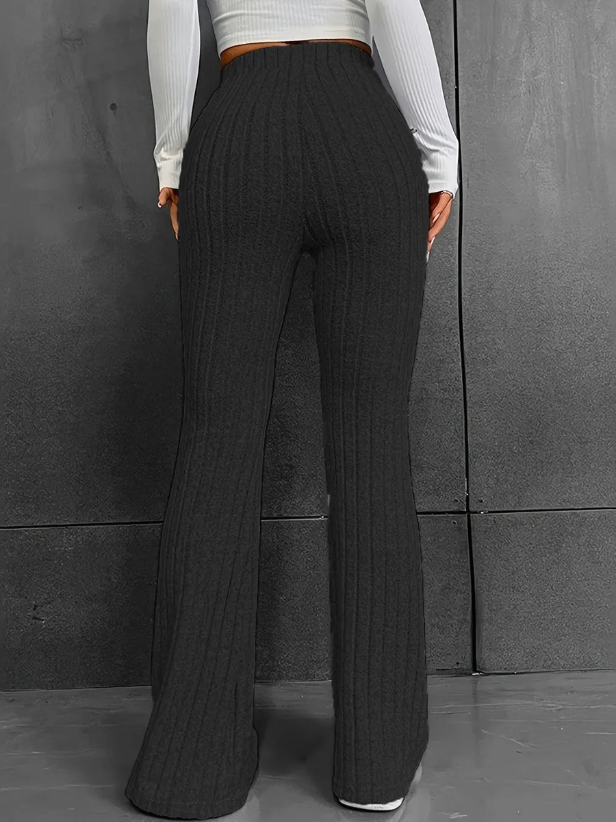 Person wearing dark ribbed wide-leg pants against a gray background