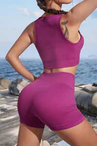 Person wearing a purple athletic outfit standing by the ocean.