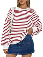 Person wearing a red and white striped sweater with a denim skirt on a white background