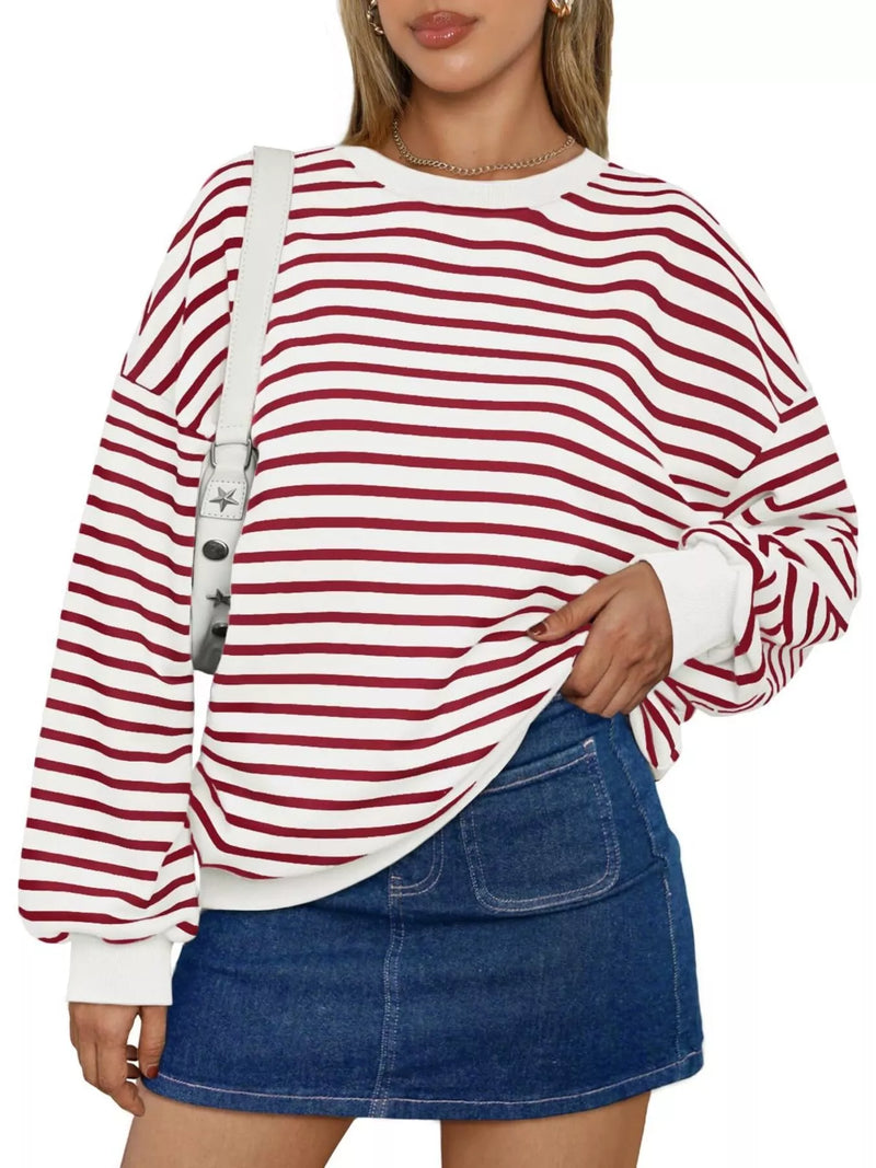 Person wearing a red and white striped sweater with a denim skirt on a white background