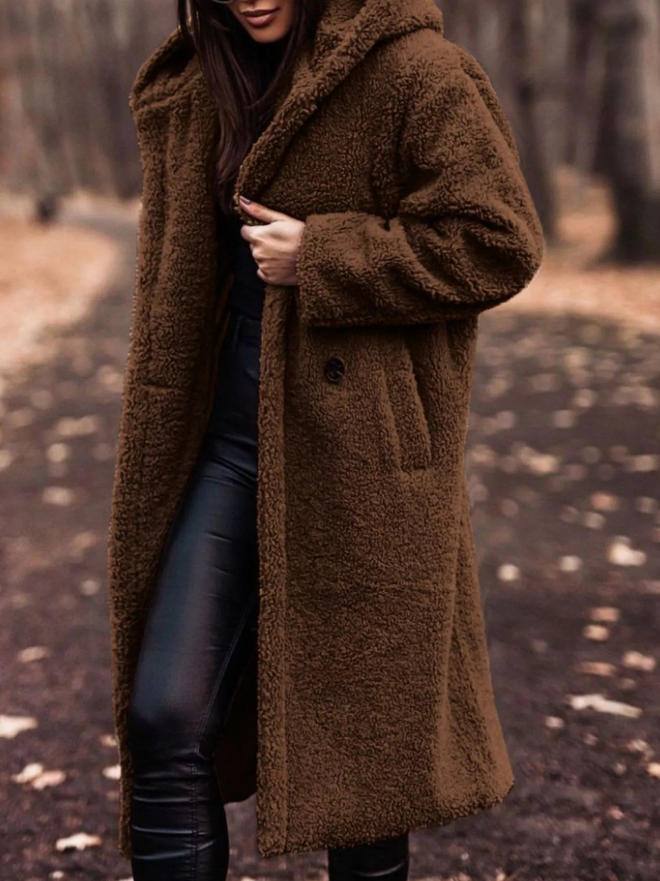 Person wearing a brown teddy coat in a forest setting