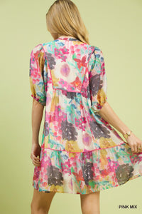 Woman wearing a colorful floral dress against a light green background