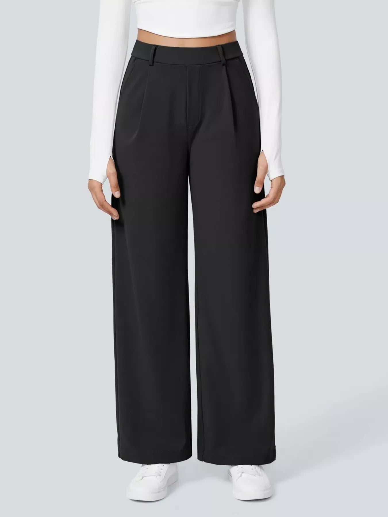Person wearing black wide-leg pants and a white top on a light gray background
