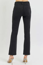 Black jeans worn by a person on a white background