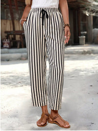 Person wearing black and white striped pants outdoors on a sunny day.