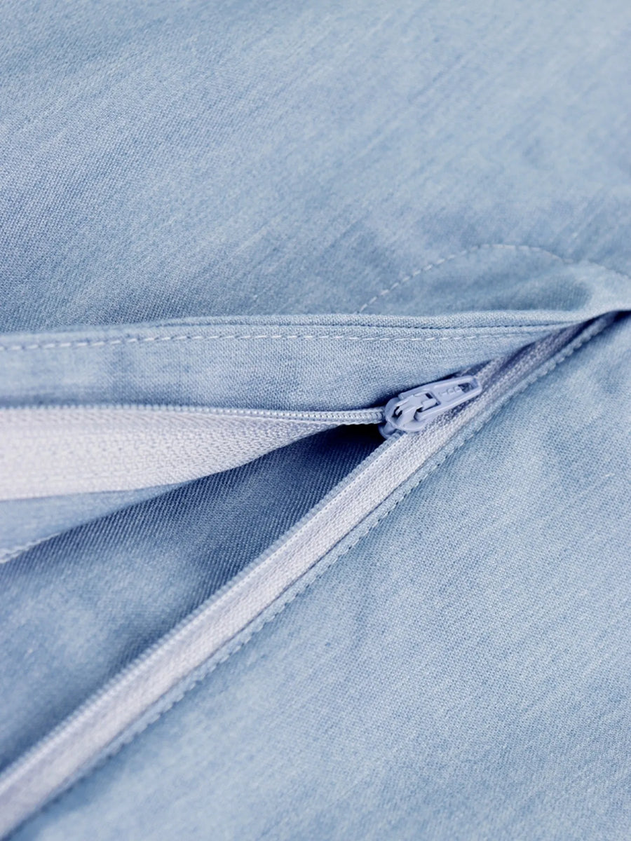 Close-up of a zipper on a light blue denim fabric