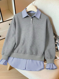Gray sweatshirt with blue striped collar and hem on a mannequin against a neutral background