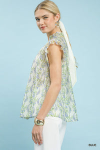 Woman wearing a floral sleeveless top against a light blue background