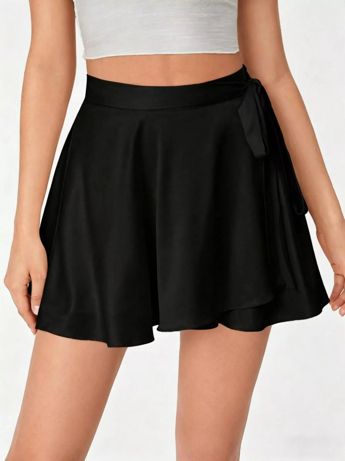 Black skirt with a tie waist worn by a person on a white background