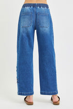 Blue jeans worn by a person on a white background