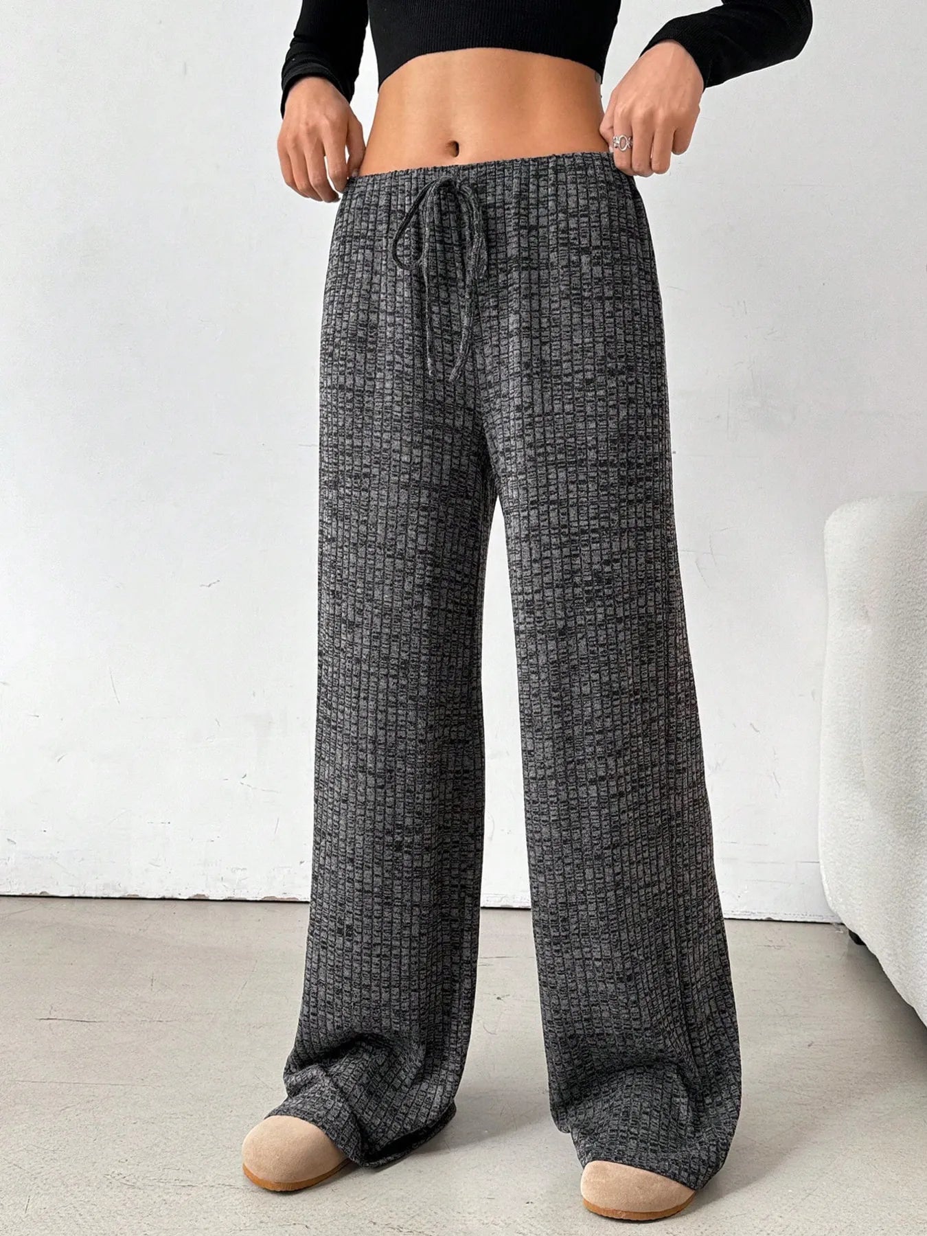 Person wearing gray checkered pajama pants on a white background