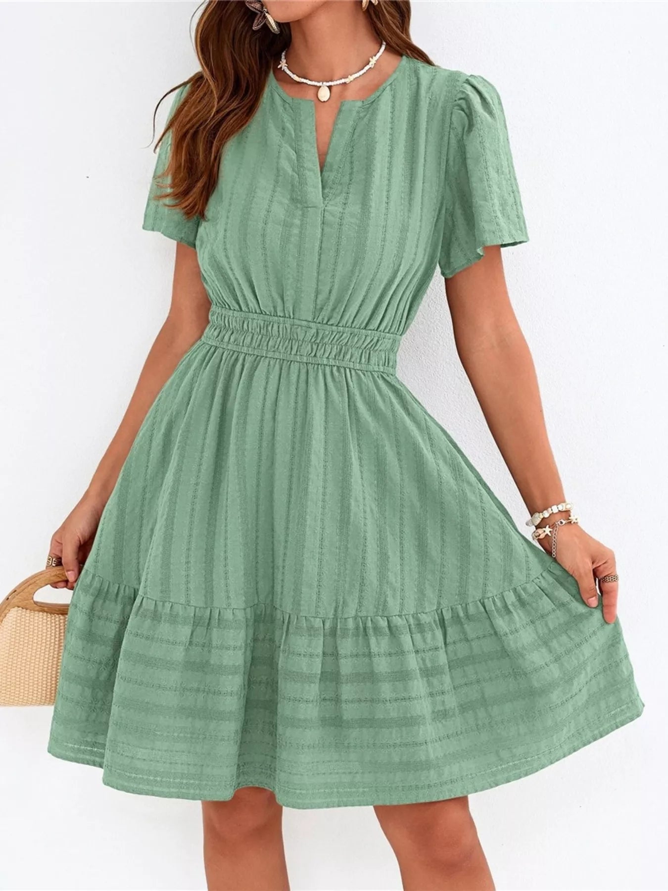 Green dress worn by a person on a white background