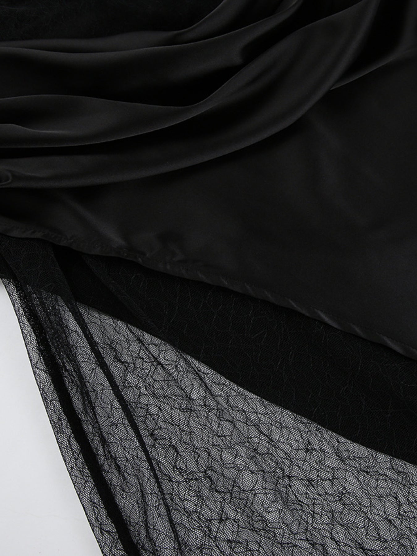 Close-up of black fabric with a textured pattern on a white background