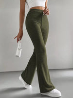 Person wearing olive green ribbed pants and white sneakers on a gray background