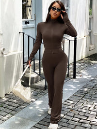 Woman in a brown outfit walking outdoors on a sunny day.