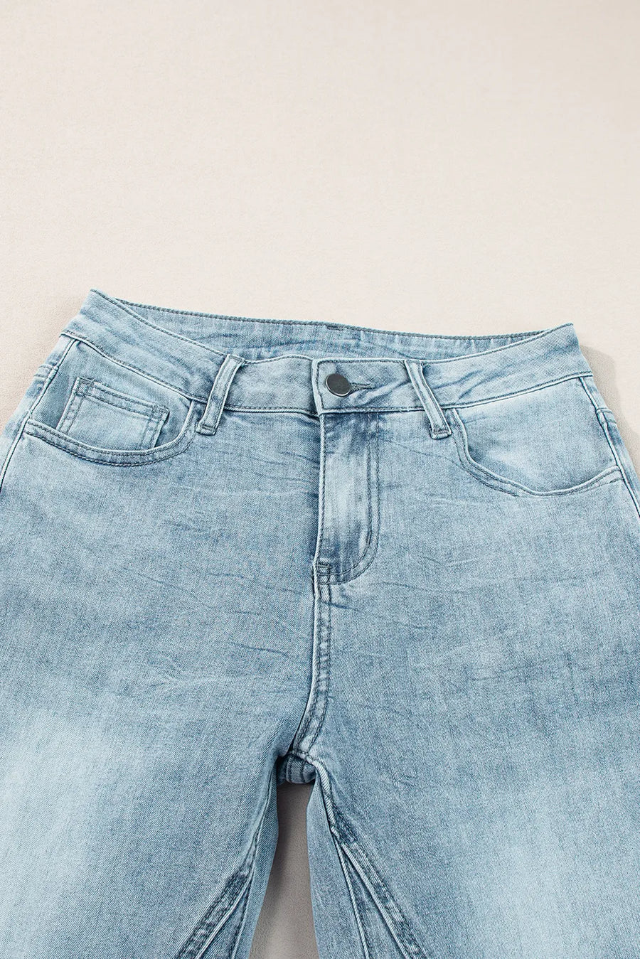 Light blue denim jeans on a light gray background