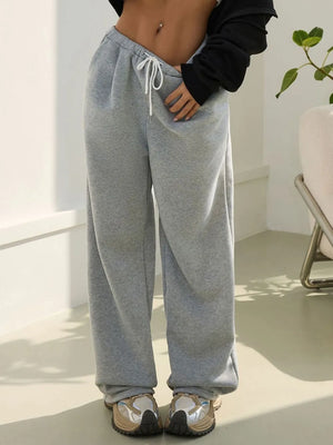Person wearing gray sweatpants in a minimal indoor setting
