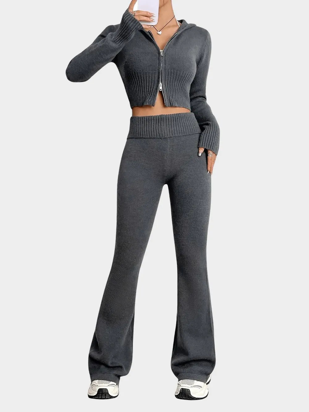 Person wearing a gray knit two-piece set on a white background