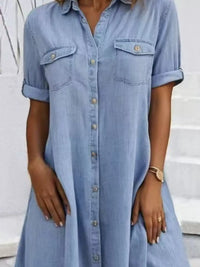 Woman wearing a light blue denim dress with a white background