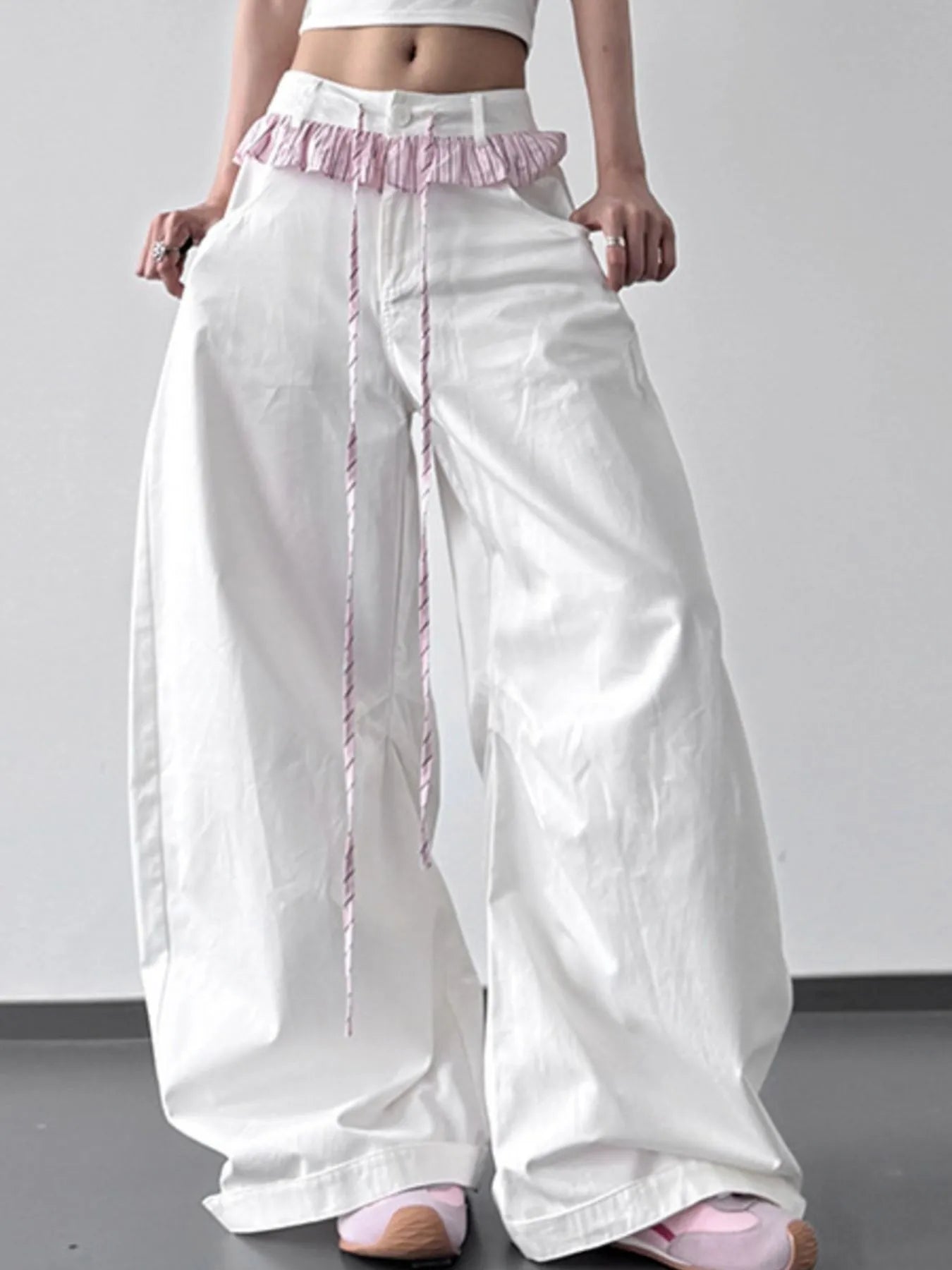 White wide-leg pants with pink trim worn by a person on a plain background