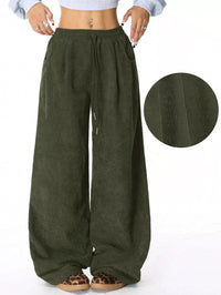 Green wide-leg pants with a close-up of the fabric texture on a white background