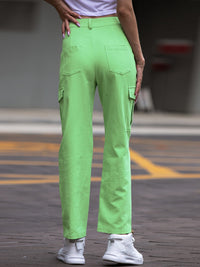 Person wearing bright green cargo pants on a blurred street background