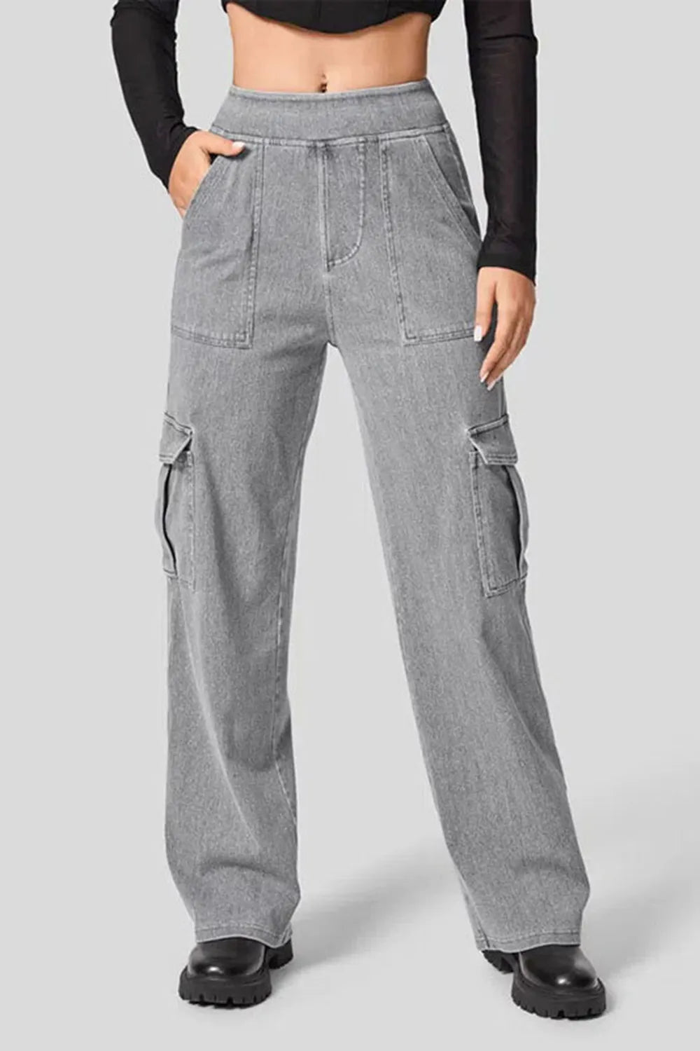 Person wearing gray cargo pants on a plain background