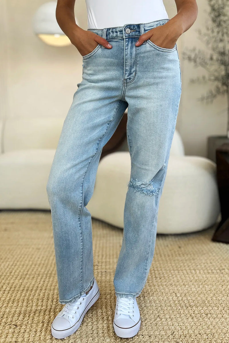 Person wearing light blue jeans and white sneakers in a casual setting